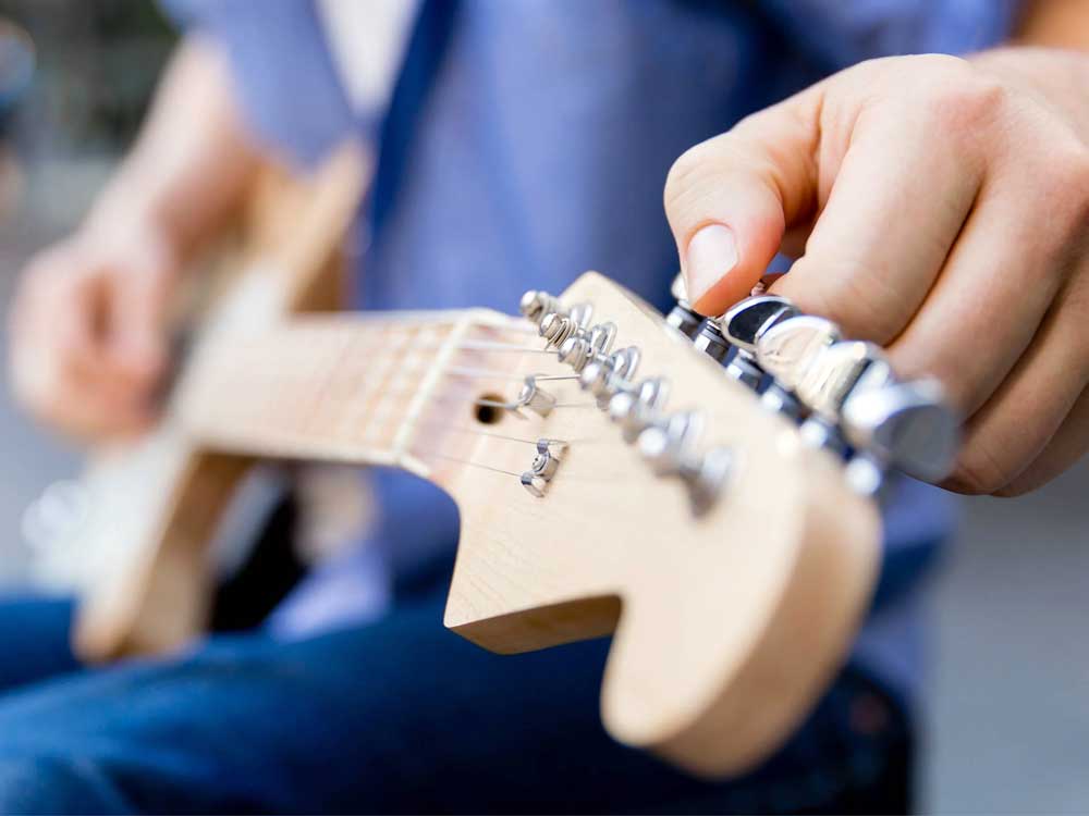fender guitar being tuned - How Often Should You Tune Your Guitar