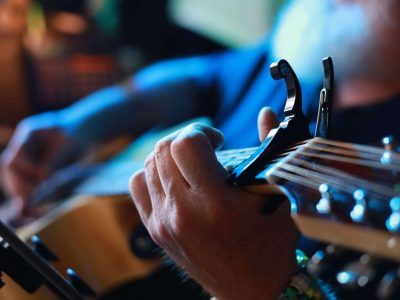 how to use capo on guitar - a person playing an acoustic guitar with a capo