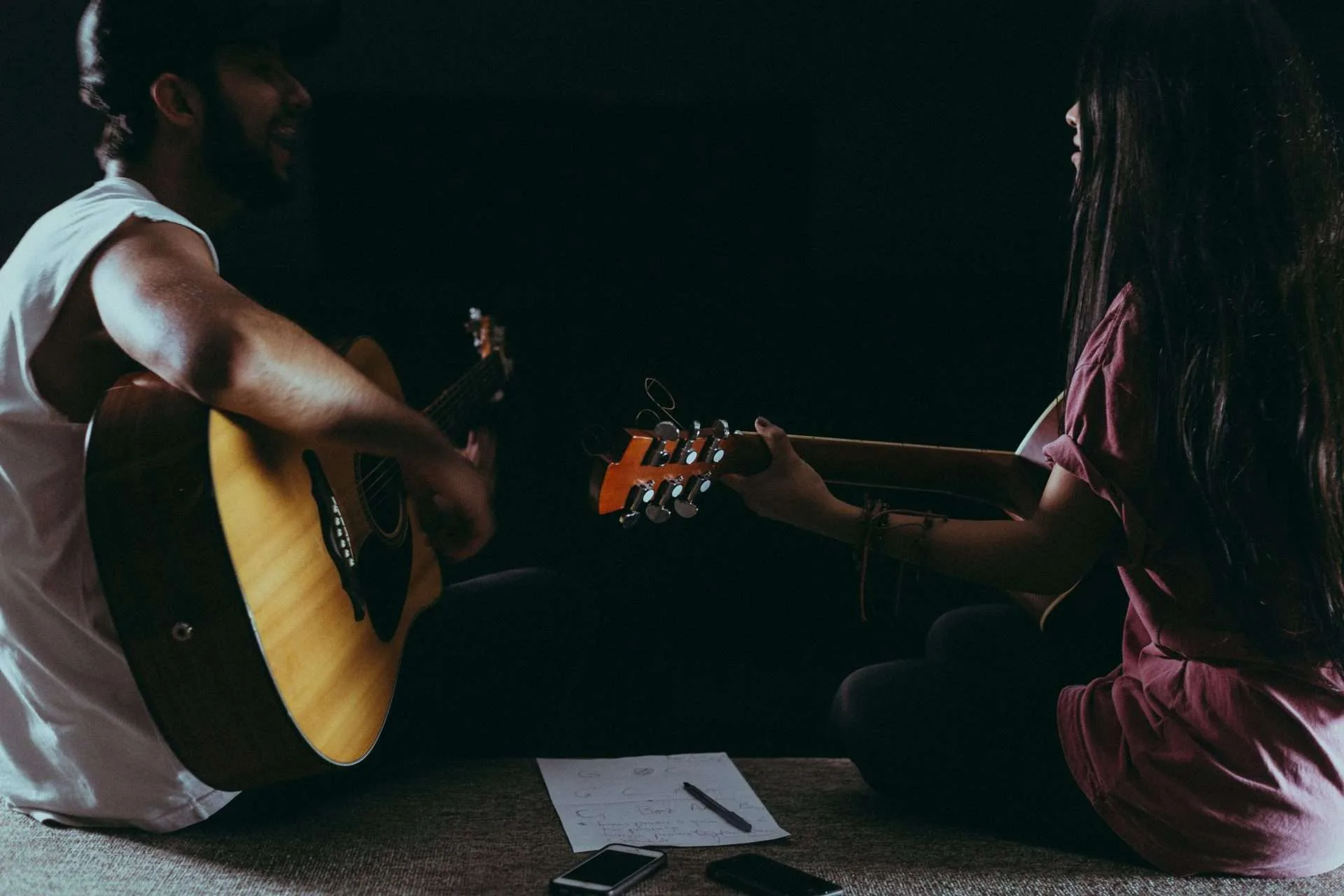 a man and a woman playing acoustic duet