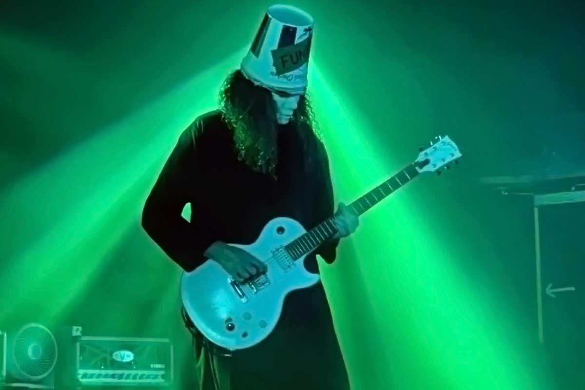 Buckethead playing live with a green background and stage lights